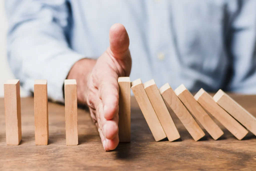 hombre negocios usando piezas madera Estrategias y herramientas para la mitigación de riesgos: Prevenir, reducir y controlar